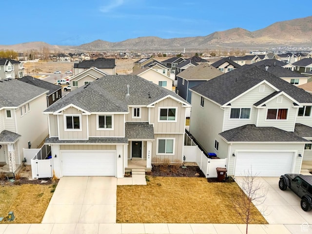 view of front of property with fence, driveway, a garage, and a residential view