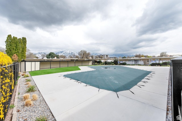 view of pool with a patio, a fenced backyard, and a mountain view