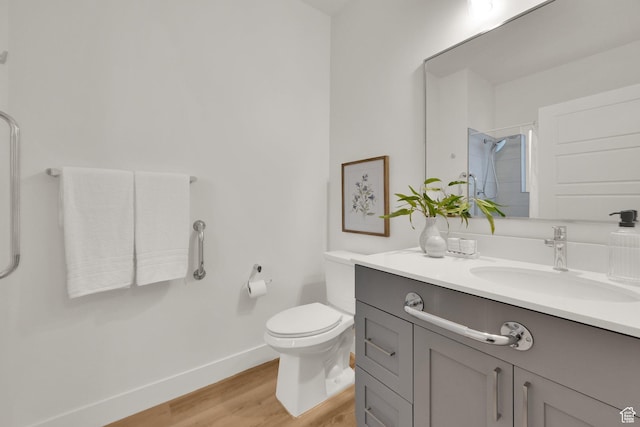 full bath with a shower, baseboards, wood finished floors, toilet, and vanity