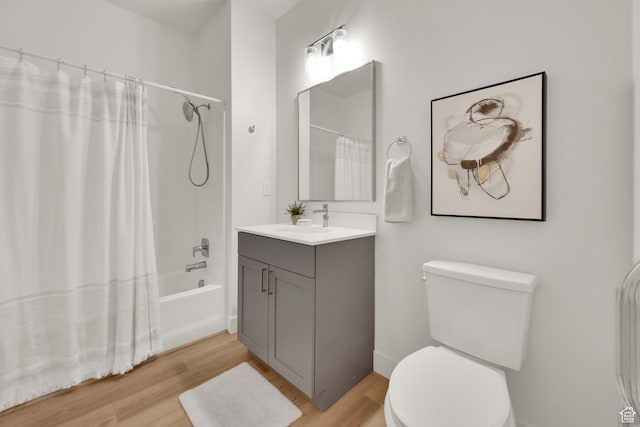 bathroom featuring wood finished floors, toilet, vanity, and shower / bathtub combination with curtain