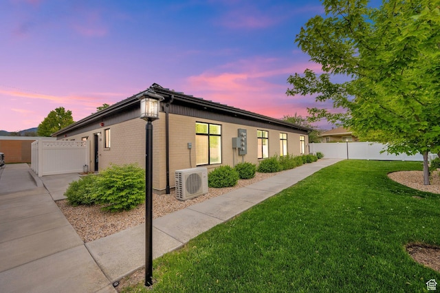 property exterior at dusk featuring ac unit and brick siding