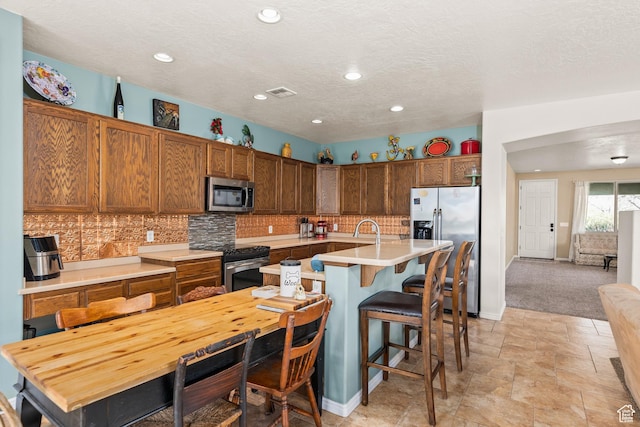 3352 E Sweetwater Springs Dr, Washington, UT 84780 - kitchen with light countertops, visible vents, tasteful backsplash, and appliances with stainless steel finishes