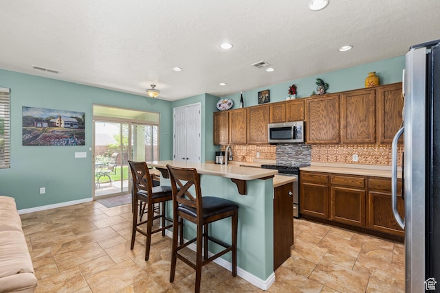 3352 E Sweetwater Springs Dr, Washington, UT 84780 - kitchen featuring brown cabinetry, stainless steel appliances, tasteful backsplash, and visible vents