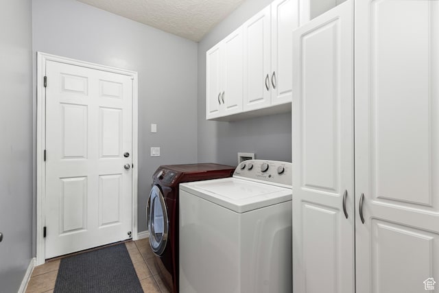 3352 E Sweetwater Springs Dr, Washington, UT 84780 - laundry room featuring light tile patterned flooring, washing machine and clothes dryer, a textured ceiling, baseboards, and cabinet space