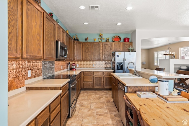 3352 E Sweetwater Springs Dr, Washington, UT 84780 - kitchen featuring a sink, brown cabinetry, stainless steel appliances, visible vents, and decorative backsplash