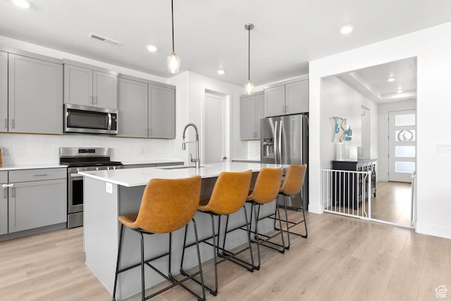 698 W Cypress Umber Dr, St George, UT 84790 - kitchen featuring a sink, gray cabinetry, light wood-style flooring, stainless steel appliances, and decorative backsplash