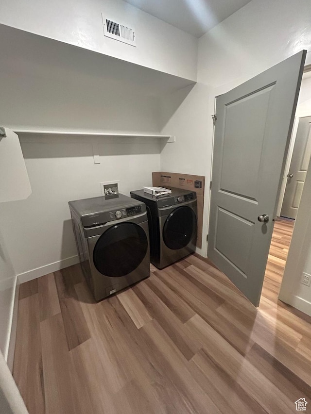 875 S Depot St E Unit C307, Clearfield, UT 84015 - clothes washing area featuring baseboards, washing machine and clothes dryer, visible vents, laundry area, and wood finished floors