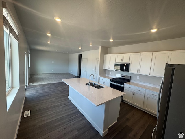 1355 N Harper Way Unit 249, Tooele, UT 84074 - kitchen with stainless steel appliances, white cabinets, open floor plan, dark wood-style flooring, and recessed lighting