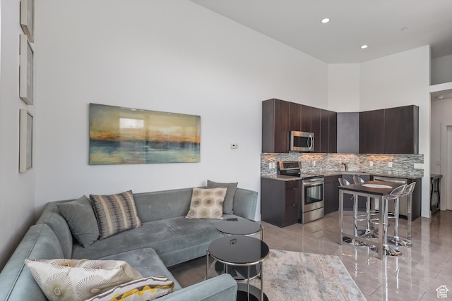 1051 W Rooftop Dr S Unit 401, Midvale, UT 84047 - living area featuring marble finish floor, a towering ceiling, and recessed lighting