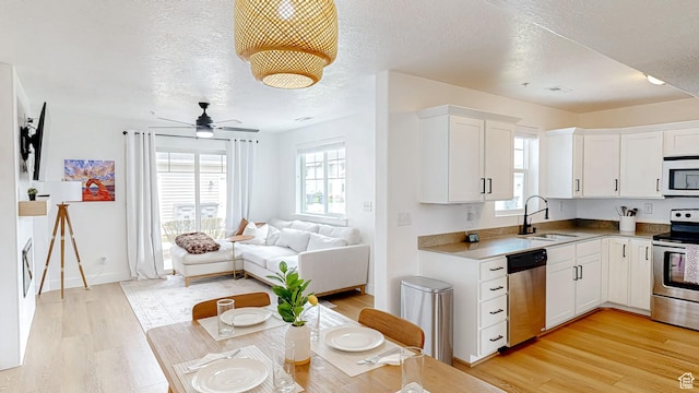 2527 W 500 S Unit 1, Springville, UT 84663 - kitchen featuring open floor plan, light wood-style flooring, a sink, and appliances with stainless steel finishes