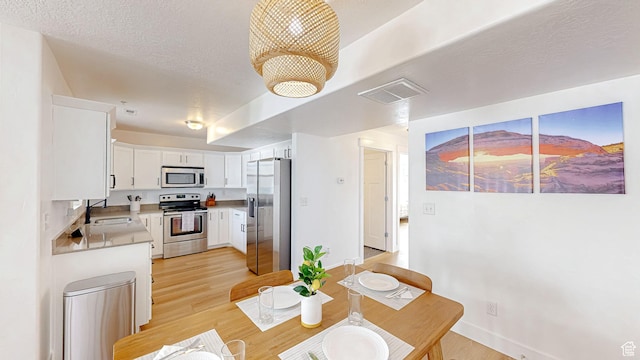2527 W 500 S Unit 1, Springville, UT 84663 - dining area featuring baseboards, visible vents, light wood-style flooring, and a textured ceiling