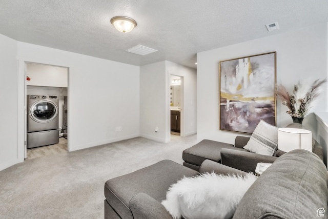 1710 S Prevedel Dr, West Haven, UT 84401 - living room featuring light colored carpet, visible vents, washer / dryer, and a textured ceiling