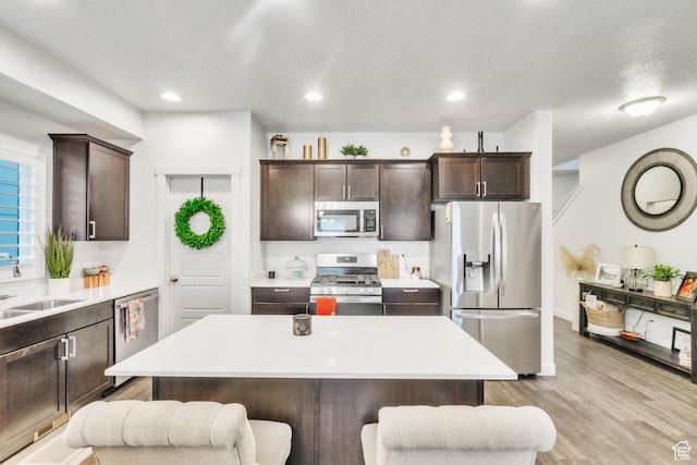 1710 S Prevedel Dr, West Haven, UT 84401 - kitchen featuring dark brown cabinetry, a breakfast bar area, a sink, and stainless steel appliances