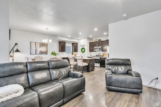 1710 S Prevedel Dr, West Haven, UT 84401 - living area featuring light wood finished floors, a textured ceiling, recessed lighting, and a chandelier