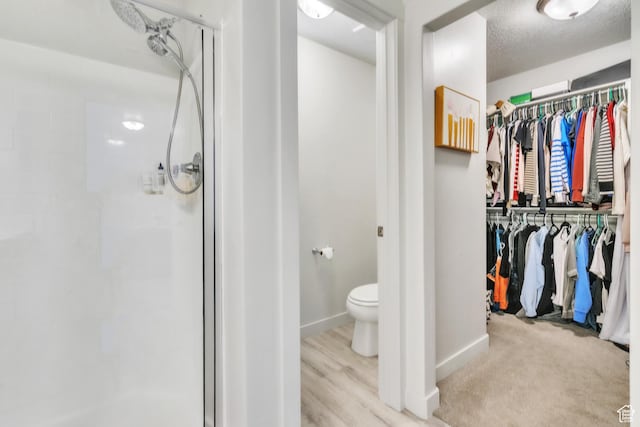 1710 S Prevedel Dr, West Haven, UT 84401 - bathroom featuring toilet, a shower stall, a walk in closet, a textured ceiling, and baseboards