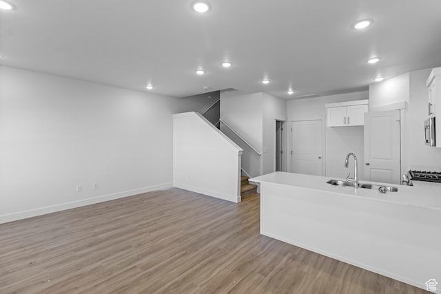 3175 S 204 W, Nibley, UT 84321 - kitchen with light wood-style flooring, a peninsula, recessed lighting, white cabinetry, and a sink