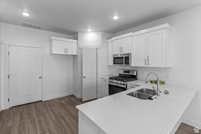 3175 S 204 W, Nibley, UT 84321 - kitchen featuring light countertops, a peninsula, appliances with stainless steel finishes, a sink, and dark wood-style floors