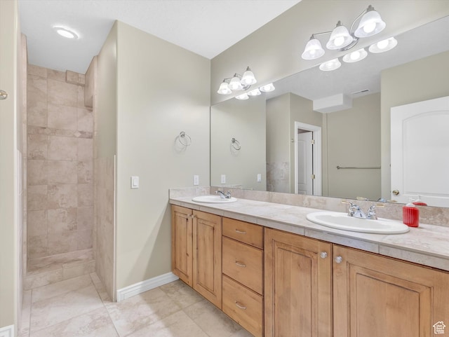 bathroom featuring a sink, tiled shower, tile patterned flooring, and double vanity