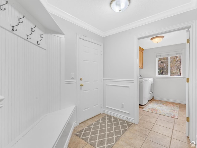 mudroom featuring separate washer and dryer, ornamental molding, and light tile patterned floors