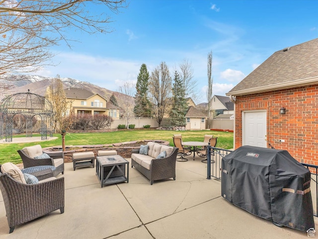 view of patio featuring an outdoor structure, outdoor lounge area, fence, a shed, and area for grilling