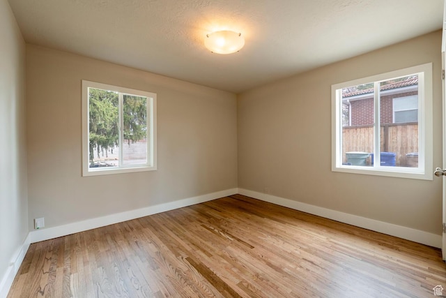 empty room featuring wood finished floors and baseboards