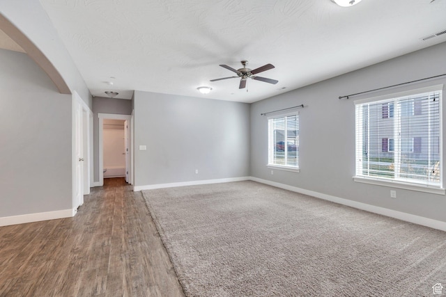 unfurnished room featuring baseboards, wood finished floors, and ceiling fan