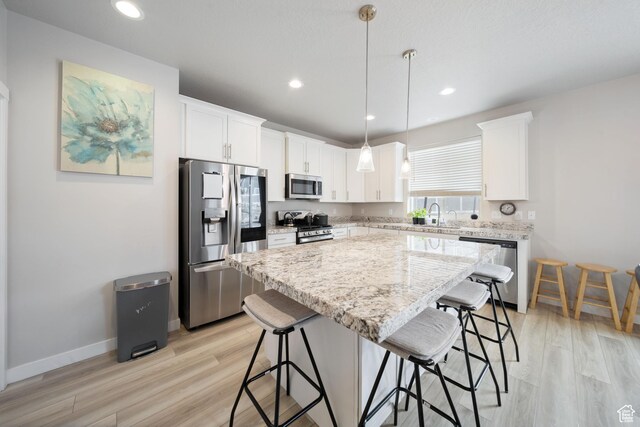 3724 E Long Ridge Dr, Eagle Mountain, UT 84005 - kitchen featuring a kitchen breakfast bar, appliances with stainless steel finishes, and light wood-type flooring