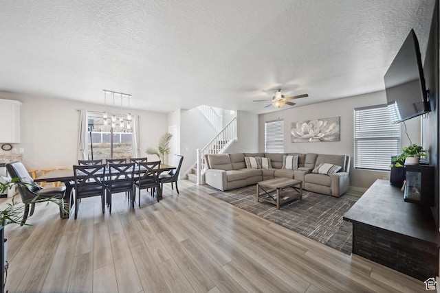3724 E Long Ridge Dr, Eagle Mountain, UT 84005 - living area featuring a textured ceiling, stairway, light wood finished floors, and ceiling fan