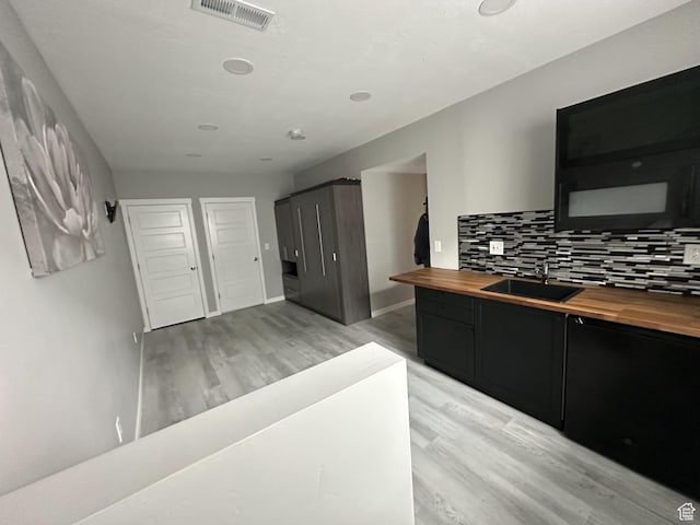3724 E Long Ridge Dr, Eagle Mountain, UT 84005 - kitchen featuring visible vents, wood counters, tasteful backsplash, a sink, and dark cabinetry