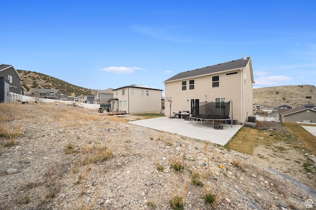 3724 E Long Ridge Dr, Eagle Mountain, UT 84005 - back of house with central AC unit, a trampoline, stucco siding, a mountain view, and a patio area
