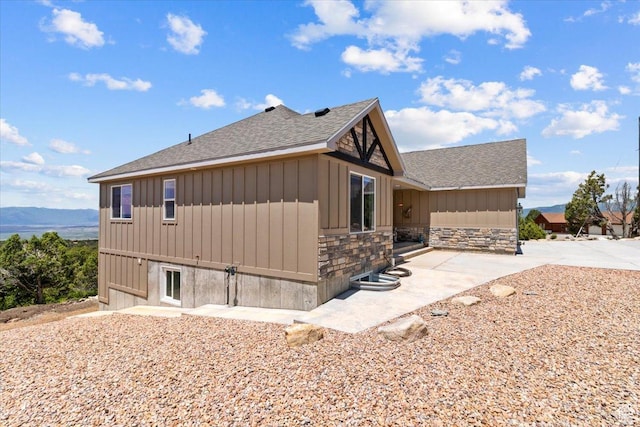 14440 N 11740 E, Mount Pleasant, UT 84647 - view of side of property with roof with shingles, stone siding, board and batten siding, and a patio