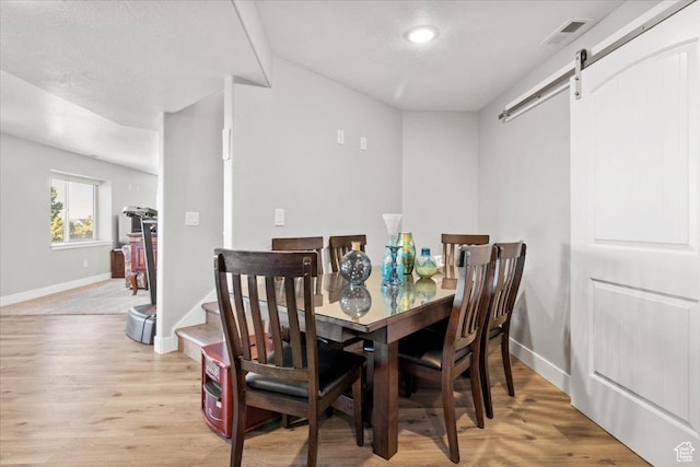 14440 N 11740 E, Mount Pleasant, UT 84647 - dining area with a barn door, baseboards, light wood finished floors, a textured ceiling, and recessed lighting