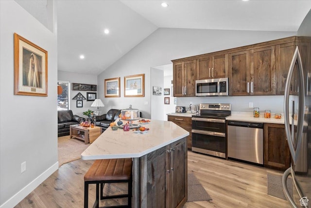 14440 N 11740 E, Mount Pleasant, UT 84647 - kitchen featuring appliances with stainless steel finishes, light wood-type flooring, open floor plan, a kitchen island, and dark brown cabinets
