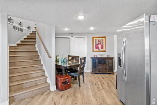 14440 N 11740 E, Mount Pleasant, UT 84647 - dining space with a barn door, stairs, a textured ceiling, light wood-style flooring, and recessed lighting