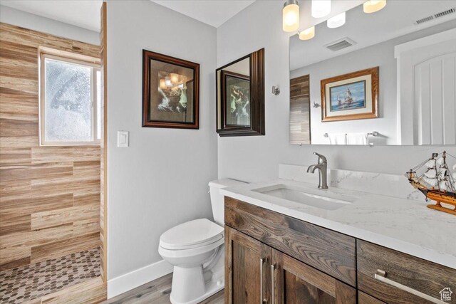 14440 N 11740 E, Mount Pleasant, UT 84647 - bathroom featuring vanity, tiled shower, toilet, wood finished floors, and baseboards
