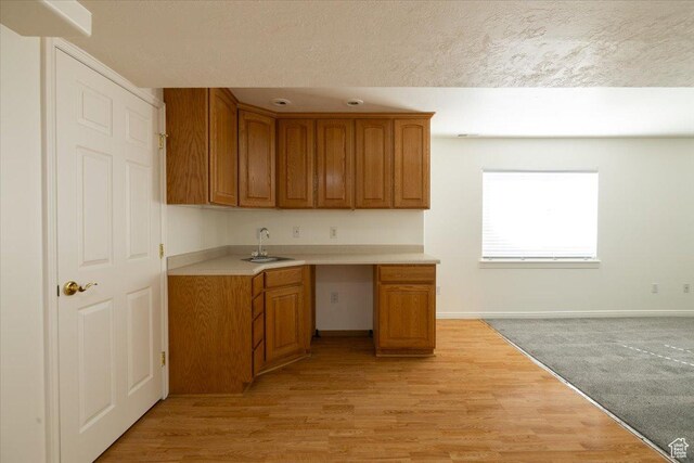 839 E 4315 S, Murray, UT 84107 - kitchen with light countertops, baseboards, brown cabinets, a sink, and light wood-style floors