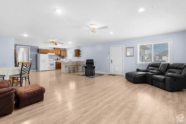 living area with light wood-type flooring, recessed lighting, and a ceiling fan