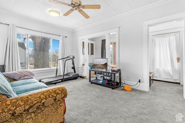 sitting room featuring baseboards, ornamental molding, ceiling fan, and carpet
