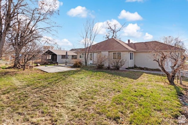 rear view of property with a lawn and a patio area