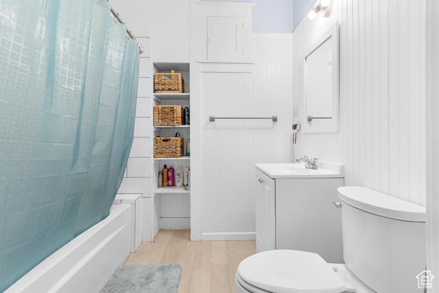 bathroom featuring toilet, vanity, shower / tub combo, and wood finished floors