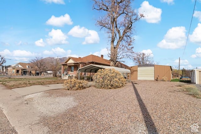 view of front of property with an outdoor structure, driveway, and a detached carport