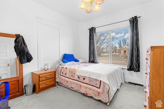 bedroom featuring light colored carpet and a chandelier