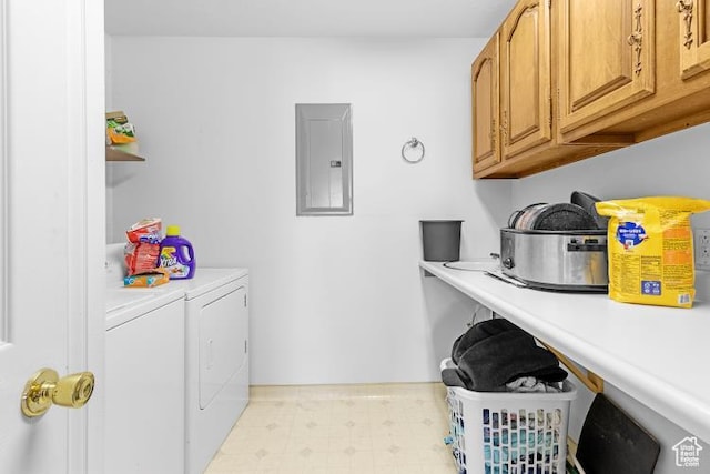 washroom with washing machine and clothes dryer, cabinet space, light floors, and electric panel
