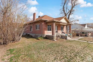 rear view of property with a lawn, a chimney, and a patio