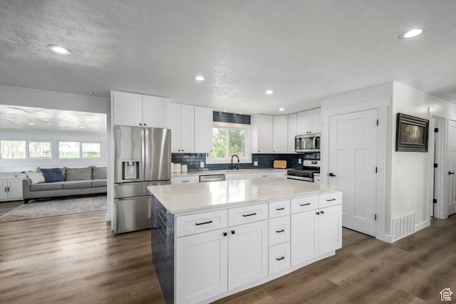 1155 E 300 N, American Fork, UT 84003 - kitchen with white cabinetry, visible vents, a kitchen island, a sink, and stainless steel appliances