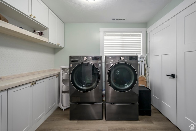 1155 E 300 N, American Fork, UT 84003 - clothes washing area featuring washer and dryer, visible vents, cabinet space, and light wood-style flooring