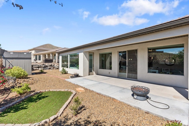 1867 W Grapevine, Hurricane, UT 84737 - rear view of house with a patio area, stucco siding, an outdoor structure, and a shed
