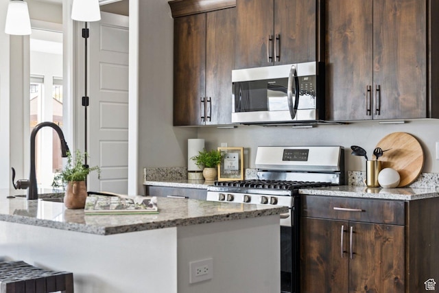 1867 W Grapevine, Hurricane, UT 84737 - kitchen with stainless steel appliances, dark brown cabinets, light stone counters, a kitchen bar, and hanging light fixtures