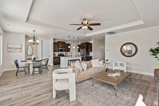 1867 W Grapevine, Hurricane, UT 84737 - living room featuring a tray ceiling, light wood-style floors, and baseboards