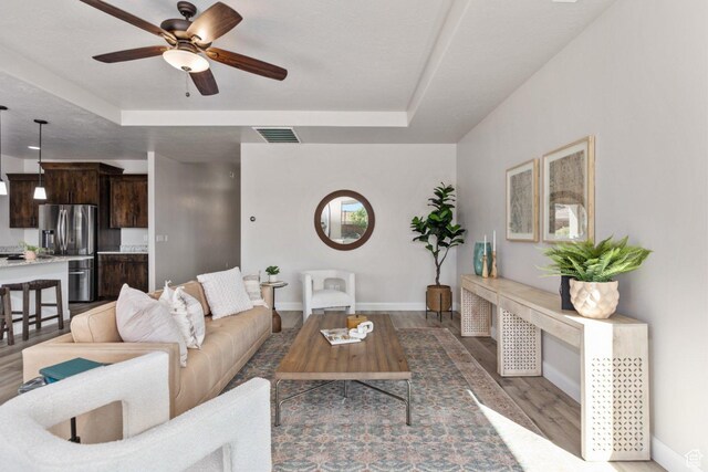 1867 W Grapevine, Hurricane, UT 84737 - living area featuring a raised ceiling, baseboards, a ceiling fan, and wood finished floors